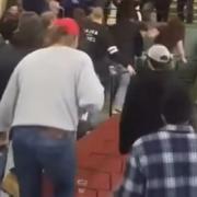Players rush into the crowd to beat up fan who threw a beer can at them.